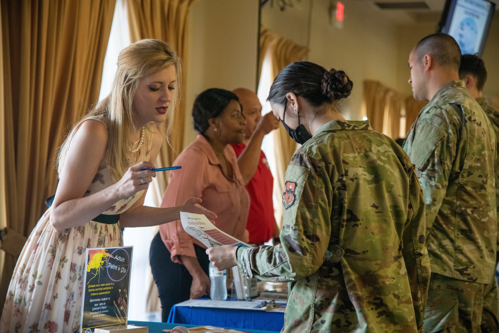 Sonya Struble, left, 56th Force Support Squadron Airman & Family Readiness Center Exceptional Family Member Program-Family Support coordinator, shares an EFMP pamphlet with Senior Airman Niki Hargrove, 310th Fighter Squadron aviation resource management apprentice, during a wing newcomer’s orientation July 20, 2021, at Luke Air Force Base, Arizona. EFMP-FS coordinators help Airmen and their families identify their immediate and long-term needs, strengths and goals to ensure they feel supported when in need of specialized assistance. The EFMP helps support Airmen and their families by providing tailored services to aid in enhancing their quality of life and level of resiliency. (U.S. Air Force photo by Staff Sgt. Collette Brooks)