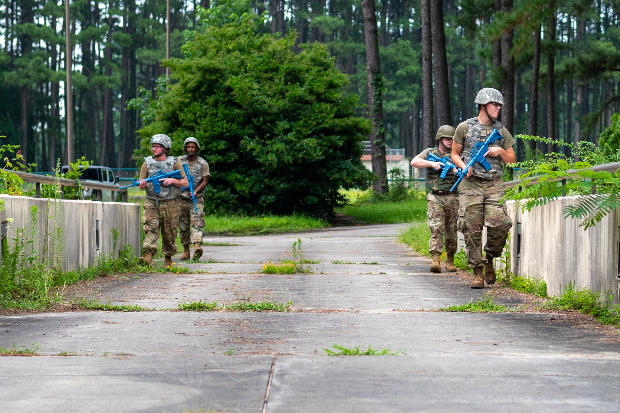 Airmen from the 4th Civil Engineer Squadron patrol an area as part of the Prime Base Engineer Emergency Force, or Prime BEEF, program at Seymour Johnson Air Force Base, North Carolina, July 20 2021. Members from the 4th CES posed as opposing forces during the training event to teach the friendly forces Airmen how to deal with scenarios they could encounter in a deployed environment. (U.S. Air Force photo by Airman 1st Class David Lynn)