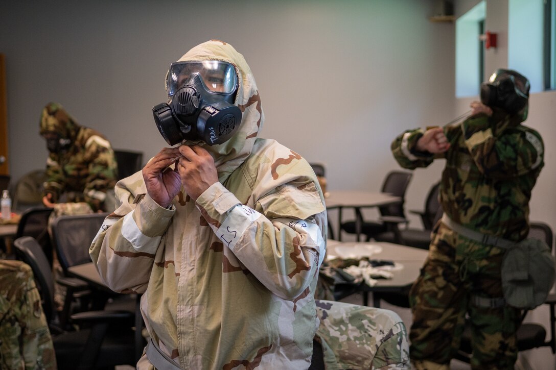 Airmen from the 4th Civil Engineer Squadron don gas masks as a part of the Prime Base Engineer Emergency Force, or Prime BEEF, program at Seymour Johnson Air Force Base, North Carolina, July 20, 2021. Donning a gas mask is one step of putting on Mission Oriented Protective Posture gear. (U.S. Air Force photo by Airman 1st Class David Lynn)