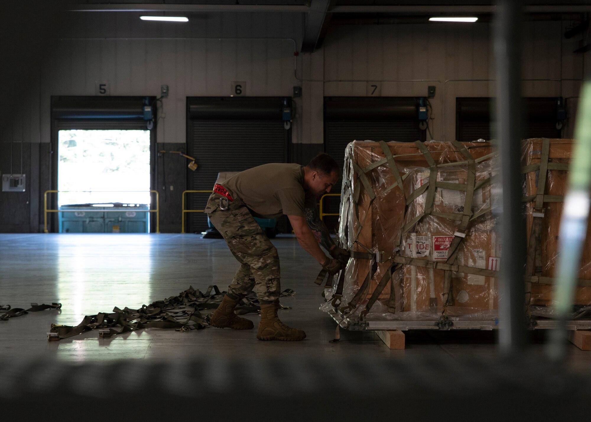 U.S. Air Force Airman 1st Class Clay Henderson, 62nd Aerial Port Squadron ramp operations representative, participates in a pallet building challenge as part of the Eagle Port Rodeo Team tryouts at Joint Base Lewis-McChord, Washington, June 24, 2021. The participants took part in five events: a pallet build-up competition, a 10K forklift skills course, a simulated aircraft upload, a combat fitness challenge and a knowledge test based on their Air Force specialty codes. (U.S. Air Force photo by Senior Airman Zoe Thacker)