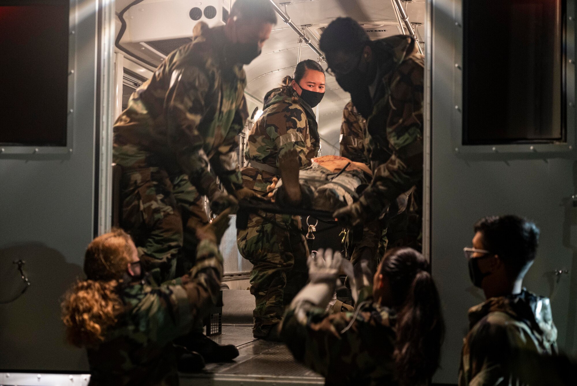 Airmen transport simulated patient to HH-60M medevac helicopter.