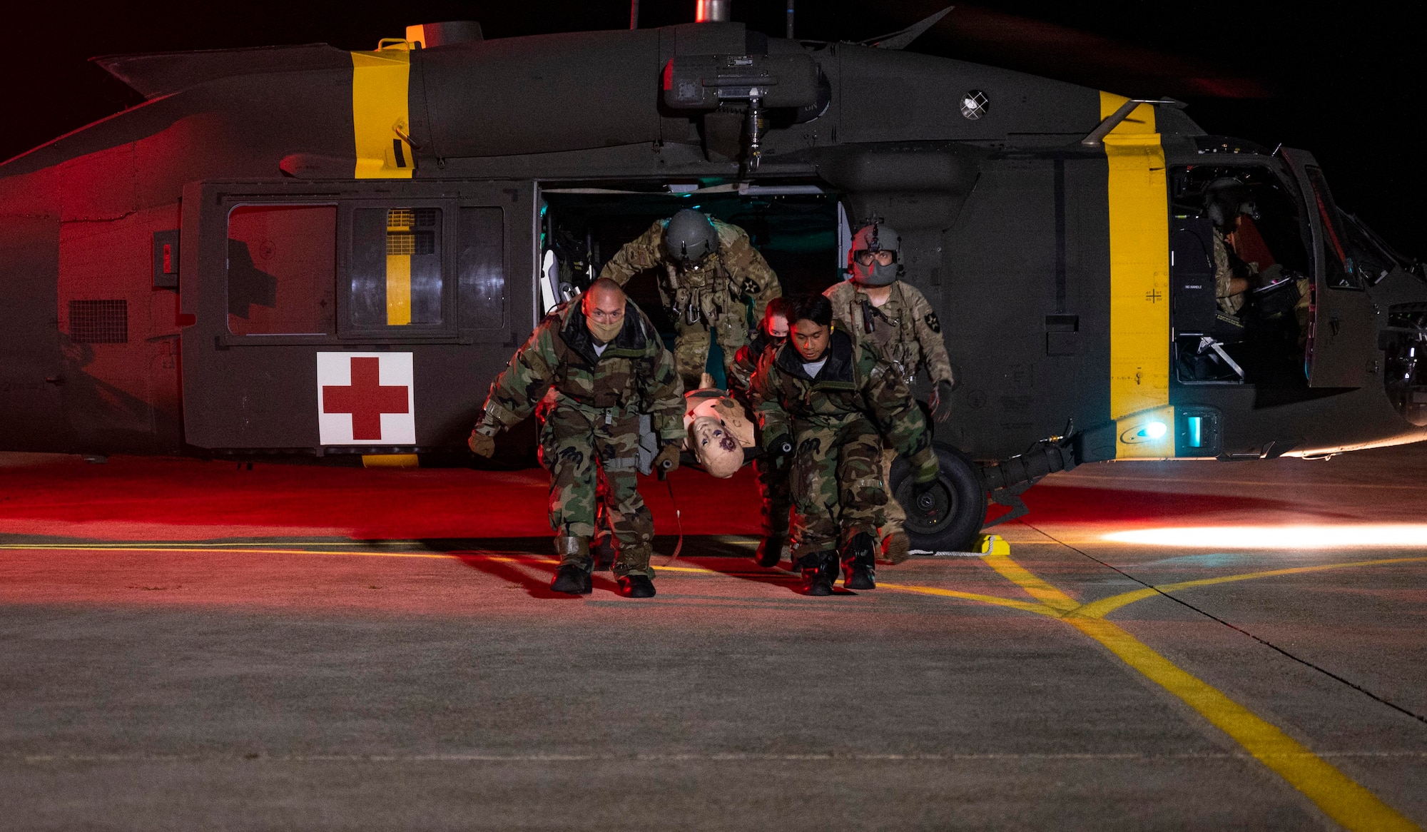 8th Medical Group Airmen transport simulated patient to HH-60M medevac helicopter.