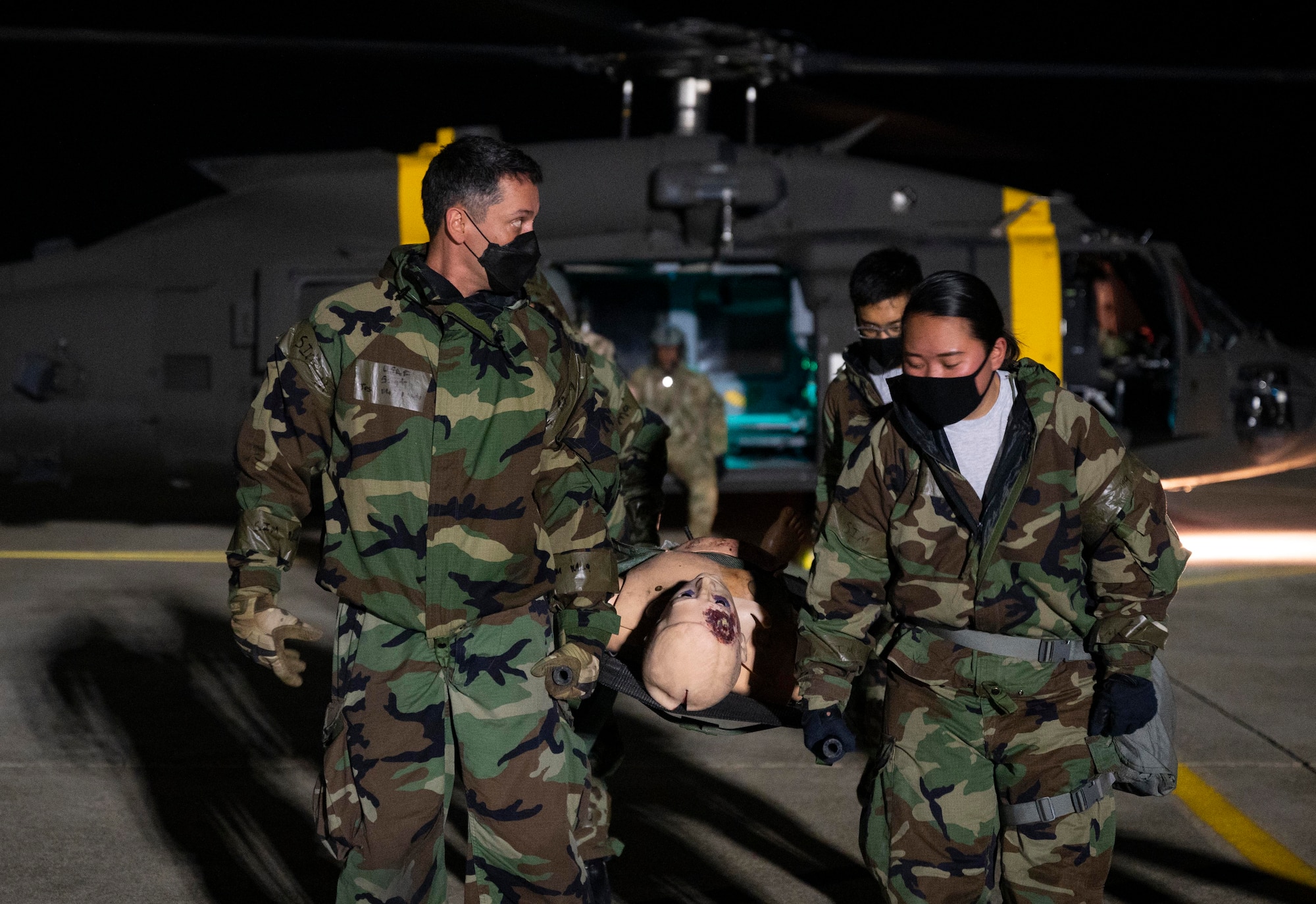 8th Medical Group Airmen transport simulated patient to HH-60M medevac helicopter.