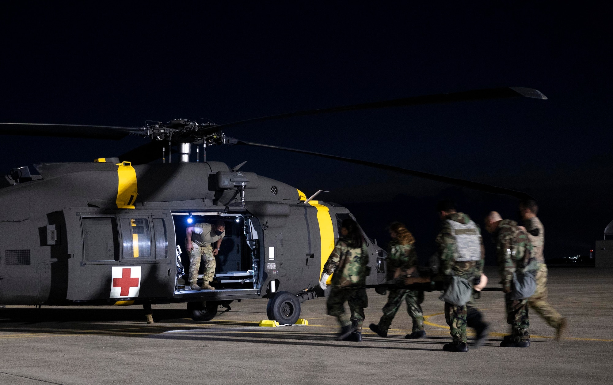 8th Medical Group Airmen transport a simulated patient to HH-60M medevac helicopter.
