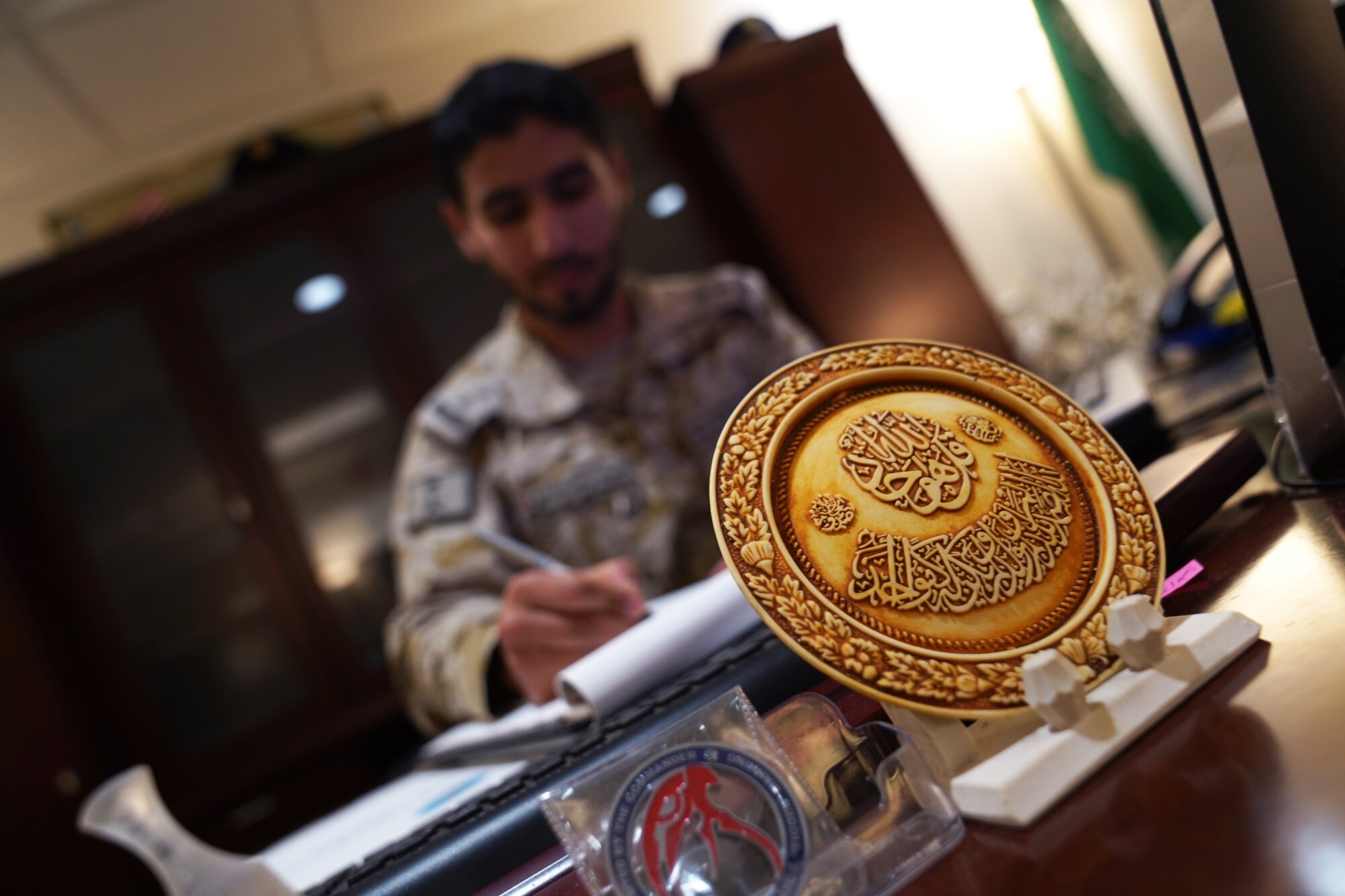 Royal Saudi air force Capt. Naif Almani, Keesler Saudi country liaison officer, performs his work duties at his desk inside the Volser Academic Development Center at Keesler Air Force Base, Mississippi, July 19, 2021. Almani provided his support for the local community by translating exams for a student in the Harrison County School District. (U.S. Air Force photo by Senior Airman Seth Haddix)