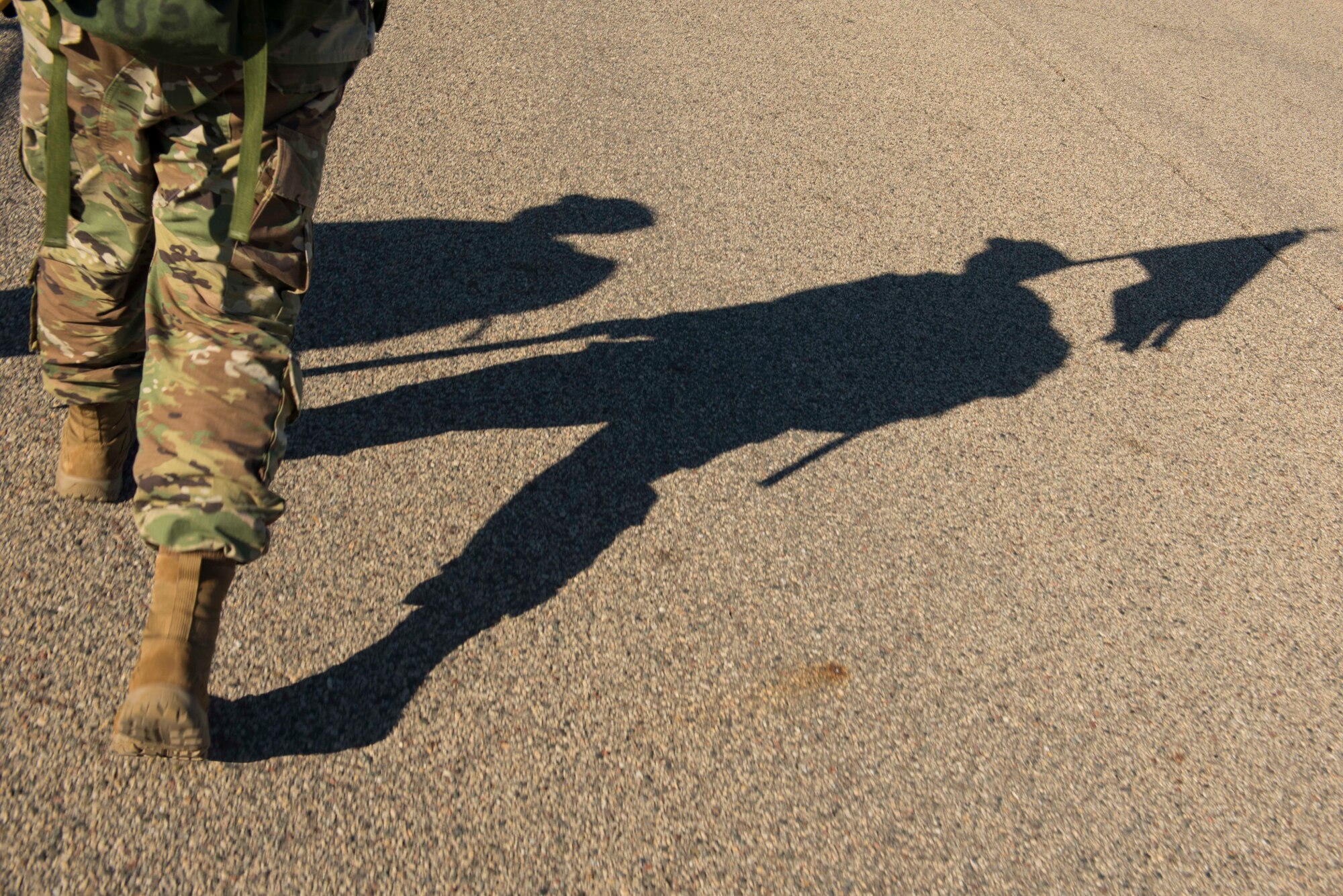 Master Sgt. Glen Kramlinger’s, 934th Security Forces Squadron plans and programs manger, shadow is displayed on the service road during a 4.5 mile ruck march in support of the Resolute Defender Ruck Challenge at Minneapolis-St. Paul Air Reserve Station, April 30, 2021. The intent for this 12 month challenge is to build and solidify resiliency, camaraderie, and communication. Currently, 40 Airmen and civilians, comprising 19 different teams, are taking part in the challenge. (Air Force photo by Chris Farley)