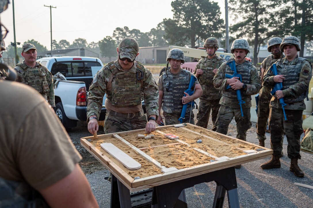 Airmen from the 4th Civil Engineer Squadron review a map of their simulated base as part of the Prime Base Engineer Emergency Force, or Prime BEEF, program at Seymour Johnson Air Force Base, North Carolina, July 22, 2021. The Prime BEEF program was three days long and featured different training portions to include air base defense, chemical, biological, radiological, and nuclear operations, and tent building. (U.S. Air Force photo by Airman 1st Class David Lynn)