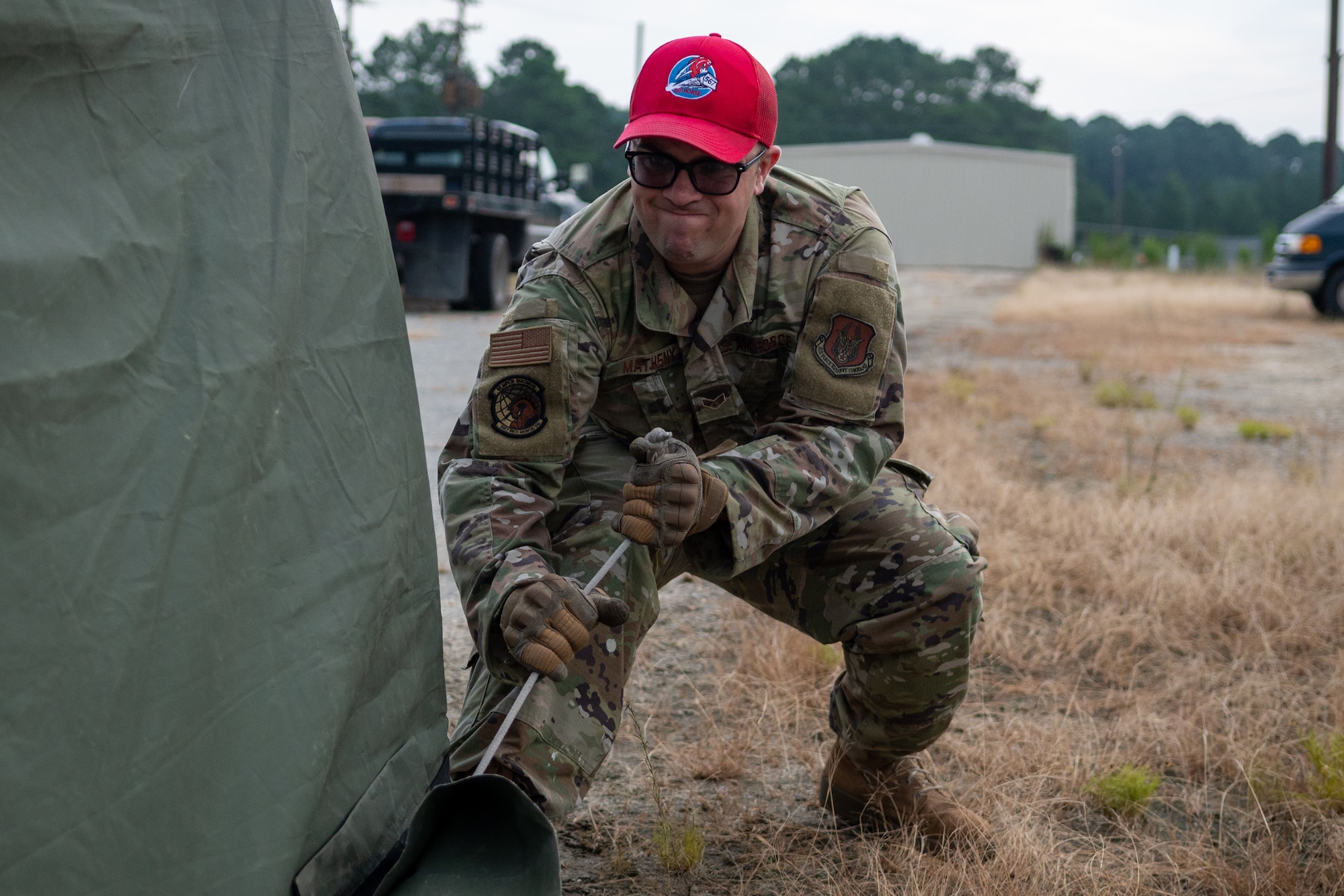 Senior Airman Dakota Matheny, 567th Red Horse Squadron structures technician, tightens a rope during the Prime Base Engineer Emergency Force, or Prime BEEF, program at Seymour Johnson Air Force Base, North Carolina, July 21, 2021. Tightening the rope was one of the last parts of the tent building portion of the Prime Base Engineer Emergency Force, or Prime BEEF, program. (U.S. Air Force photo by Airman 1st Class David Lynn)