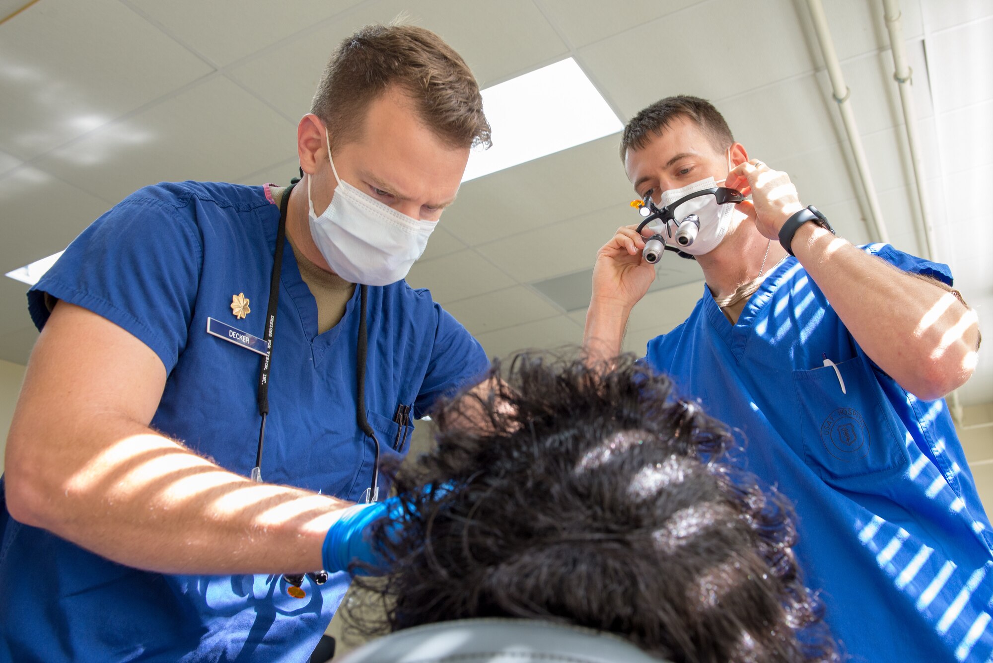 U.S. Air Force Maj. Troy Decker, a dentist from Eglin Air Force Base, and Capt. Bradley Phares, a dentist from Little Rock Air Force Base, examines a patient's dentures at Greenville High School, Miss., July 9, 2021. Dental service is provided at no charge and with no insurance necessary. (U.S. Air National Guard photo by Airman Tyler Catanach)