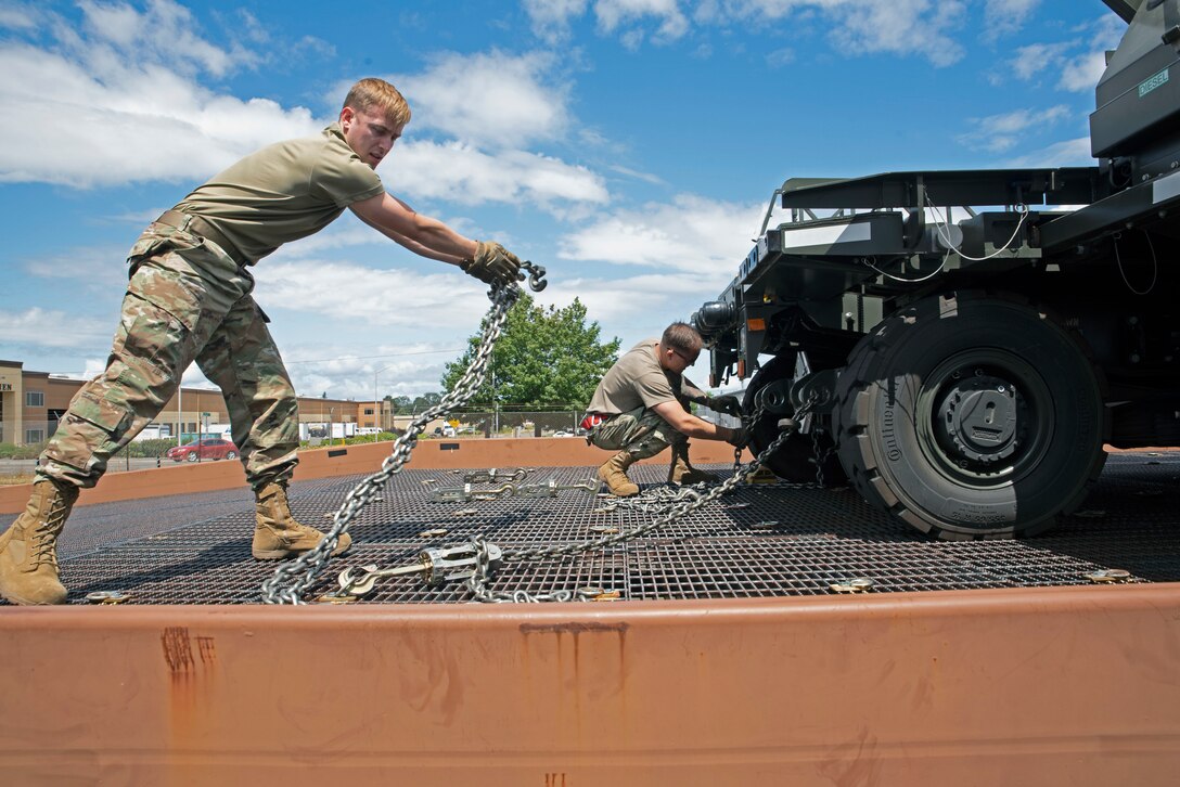 (From left) U.S. Air Force Senior Airman Trenton Dancer, air freight operations specialist, and U.S. Air Force Airman 1st Class Clay Huddleston, ramp services technician, both with the 62nd Aerial Port Squadron, simulate an aircraft upload during training at Joint Base Lewis-McChord, Washington, July 21, 2021. Dancer and Huddleston are two of the seven Airmen who will represent the 62nd APS at the 2021 Pacific Air Forces (PACAF) Port Dawg Rodeo at Joint Base Pearl Harbor-Hickam, Hawaii, in August. (U.S. Air Force photo by Senior Airman Zoe Thacker)