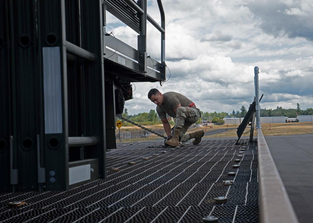 U.S. Air Force Tech. Sgt. Ronald West, NCO in charge of fleet operations with the 62nd Aerial Port Squadron, secures a vehicle during an aircraft upload training at Joint Base Lewis-McChord, Washington, July 21, 2021. West is one of the team leads for the seven Airmen who will be traveling to Joint Base Pearl Harbor-Hickam, Hawaii, in August to compete in the 2021 Pacific Air Forces (PACAF) Aerial Port Dawg Rodeo. (U.S. Air Force photo by Senior Airman Zoe Thacker)
