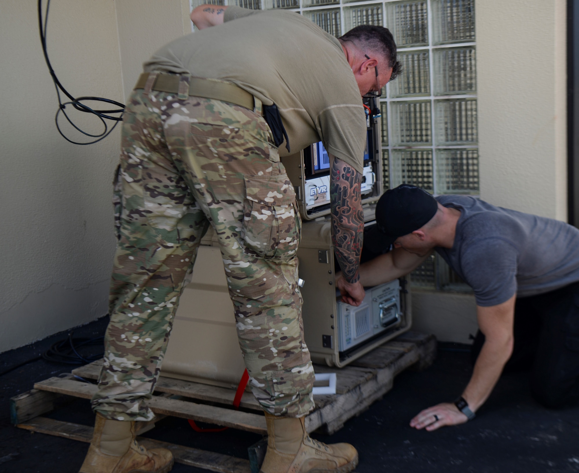 Two Airmen install a radar.