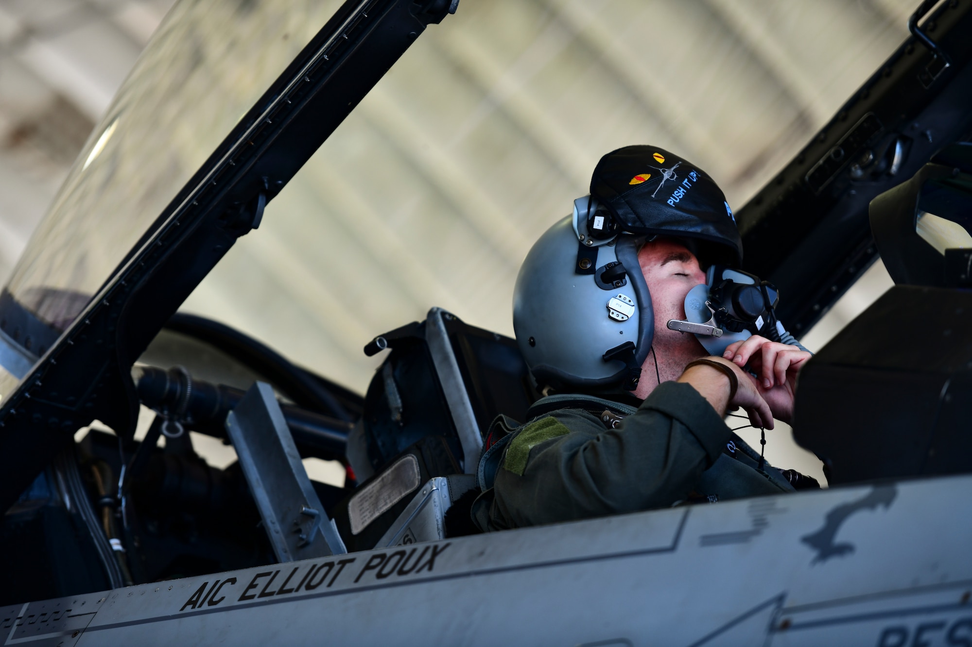 A pilot adjusts his helmet.