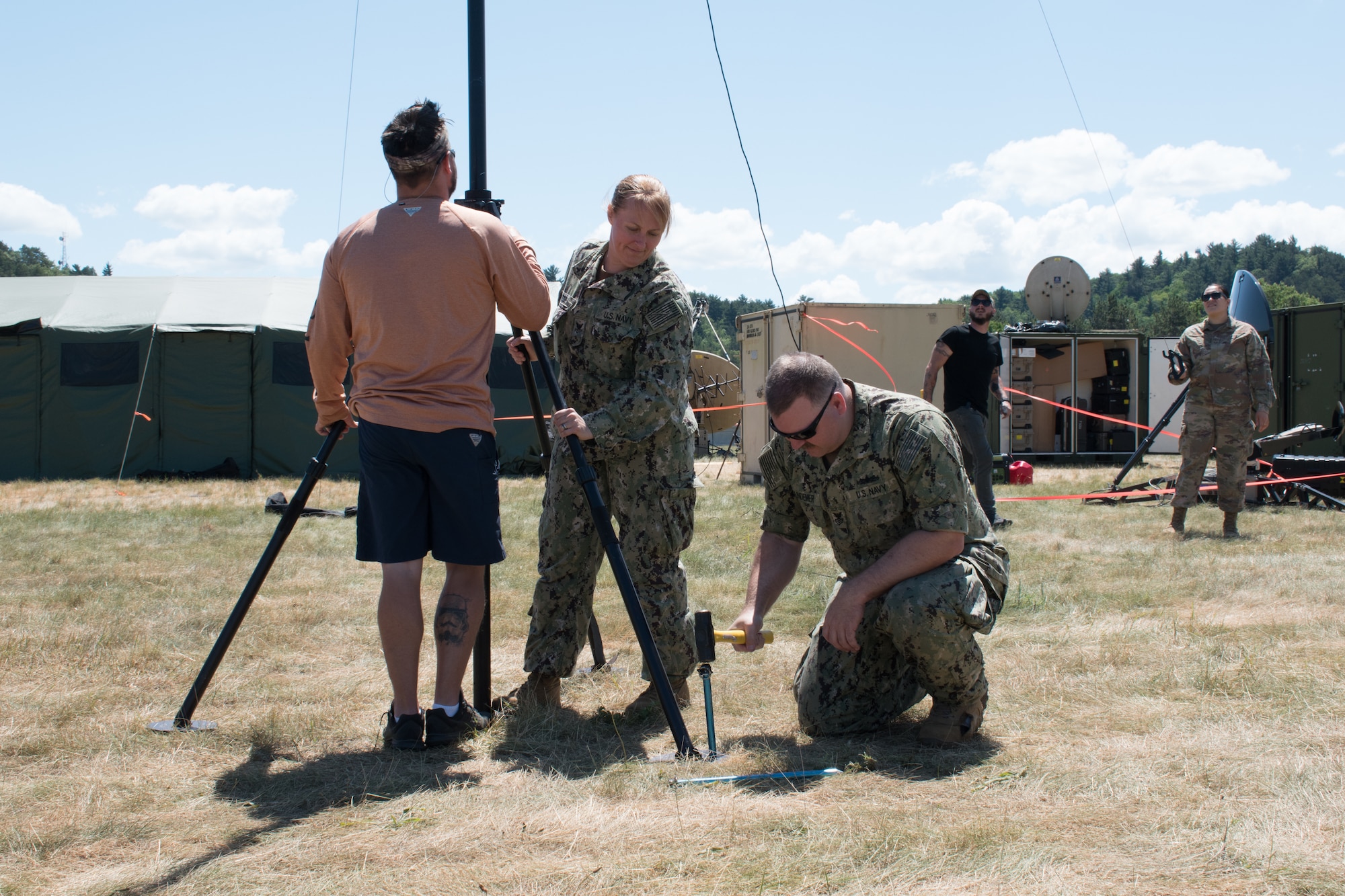 VOLK FIELD, Wis. (June 15, 2021) – Electronics Technician 1st Class Marshall Hundemer, Electronics Technician 2nd Class Amanda Yazzie, from Navy Central Command Mobile Ashore Support Team Dets A and B, and John Knorr, an infrastructure technician from Copper River Enterprise Services, install a HAM radio HF antenna on Volk Field, Wisconsin during exercise Patriot 21.  The HF antenna is being tested for interoperability from amateur HAM radio operators to military HAM radios during Patriot 21. Patriot 21 is a training exercise designed for civilian emergency management and responders to work with military entities in the same manner that they would during disaster. (U.S. Navy photo by Mass Communication Specialist 1st Class Sandi Grimnes Moreno)