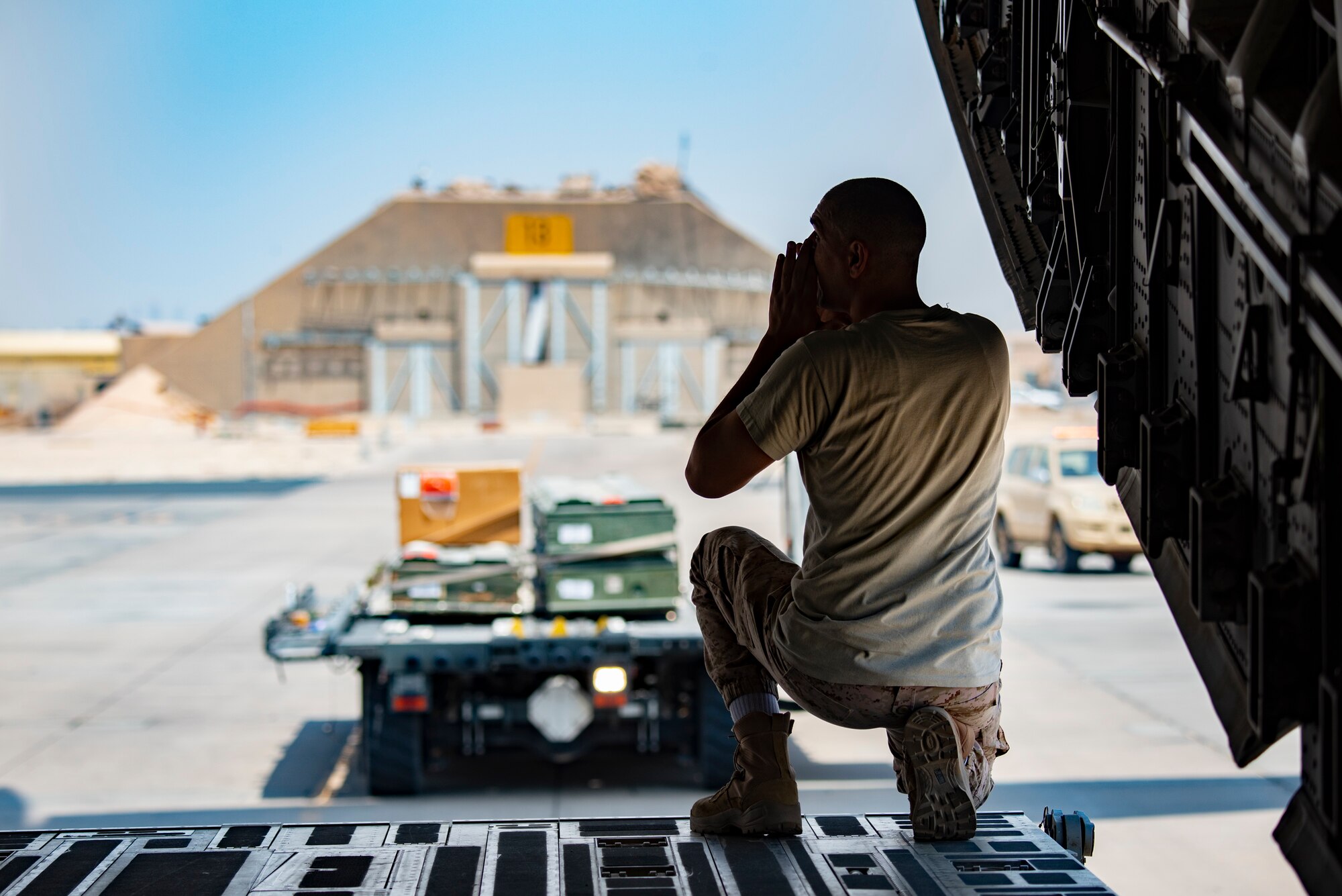 A Kuwait Air Force member directs a K-loader to a Kuwait Air Force C-17 Globemaster III at Ali Al Salem Air Base, Kuwait, July 26, 2021. One of the priorities of the 386th Air Expeditionary Wing is to foster enduring partnerships. These partnerships are built on mutual respect and critical to current and future missions. (U.S. Air Force Senior Airman Helena Owens)