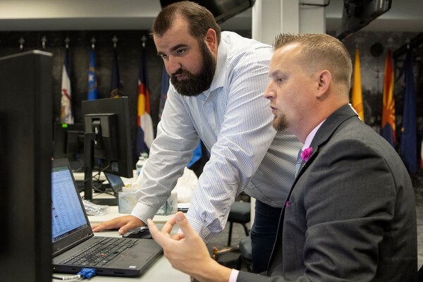 Scott Ferge, U.S. Army Financial Management Command systems accountant, right, talks with Brian Hardesty, Defense Finance and Accounting Service general ledger branch division chief, during the Army’s mock fiscal yearend closeout at the Maj. Gen. Emmett J. Bean Federal Center July 19. Mock yearend is an exercise designed to prepare the U.S. Army Financial Management Command and its partners, like DFAS, for the fiscal yearend closeout and financial statement preparation at the start of October. (U.S. Army photo by Mark R. W. Orders-Woempner)