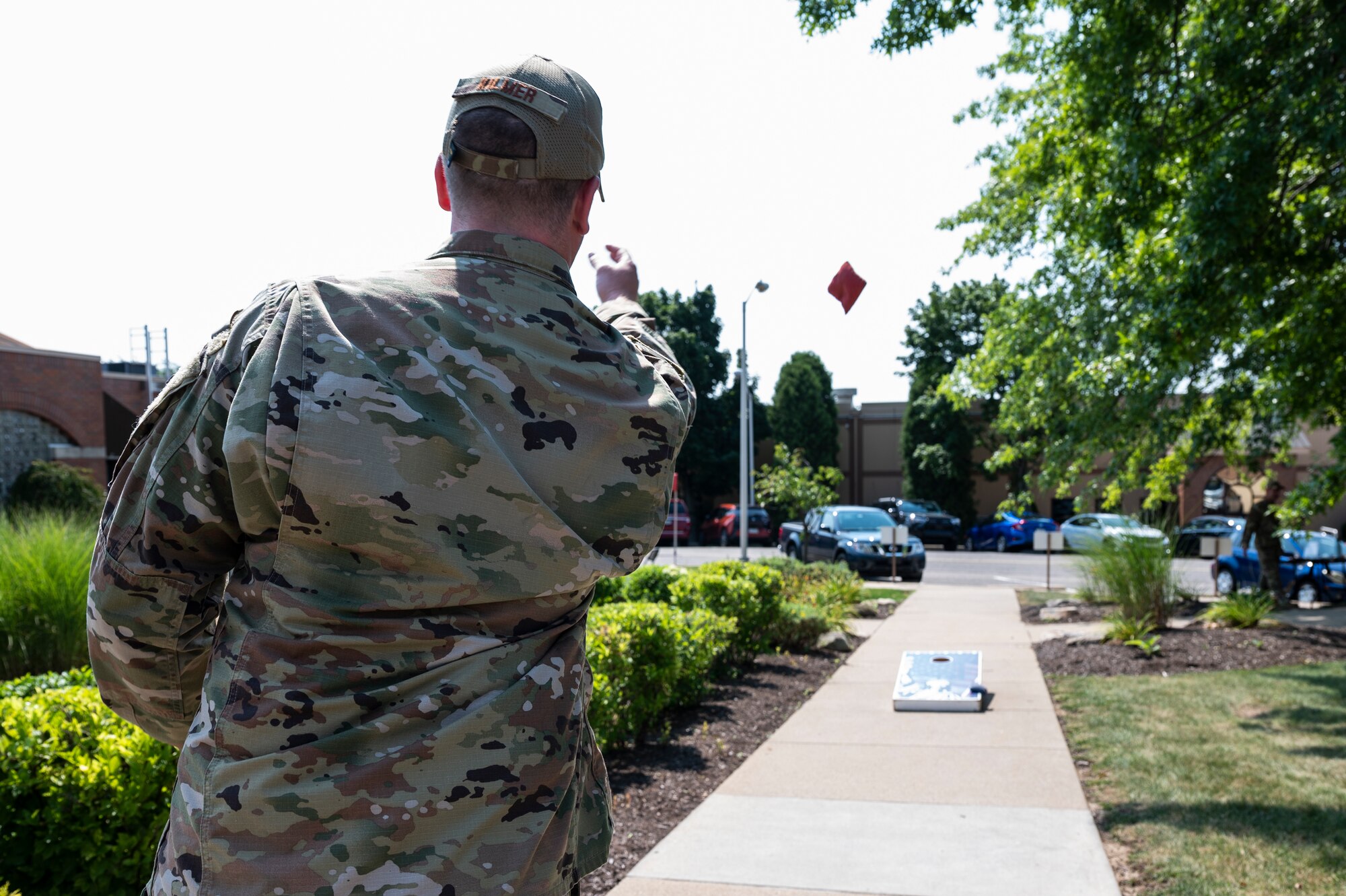 Master Sgt. Jai Kilmer, 911th Maintenance Group quality assurance inspector, tosses a beanbag as part of a cornhole contest during a burger burn held by the 911th Force Support Squadron at the Pittsburgh International Airport Air Reserve Station, Pennsylvania, July 27, 2021 The 911th FSS held the burger burn, which included the cornhole contest, as a way to increase Air Force Club membership and thank current members.