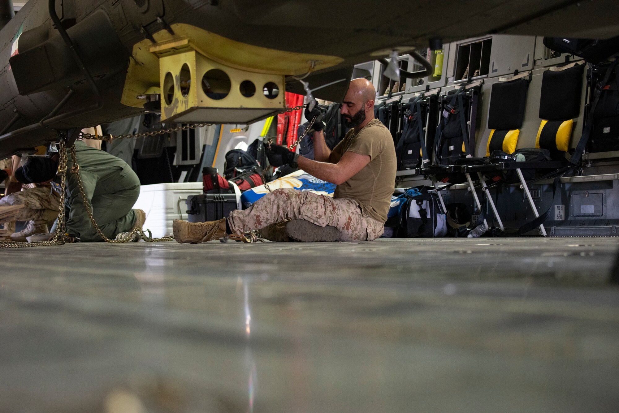 A Kuwait Air Force member secures an AH-64E APACHE inside of a Kuwait Air Force C-17 Globemaster III at Ali Al Salem Air Base, Kuwait, July 26, 2021. One of the priorities of the 386th Air Expeditionary Wing is to foster enduring partnerships. These partnerships are built on mutual respect and critical to current and future missions. (U.S. Air Force Senior Airman Helena Owens)