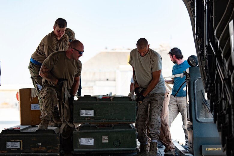 U.S. Airmen and members of the Kuwait Air Force load a case on a Kuwait Air Force C-17 Globemaster III at Ali Al Salem Air Base, Kuwait, July 26, 2021. One of the priorities of the 386th Air Expeditionary Wing is to foster enduring partnerships. These partnerships are built on mutual respect and critical to current and future missions. (U.S. Air Force Senior Airman Helena Owens)