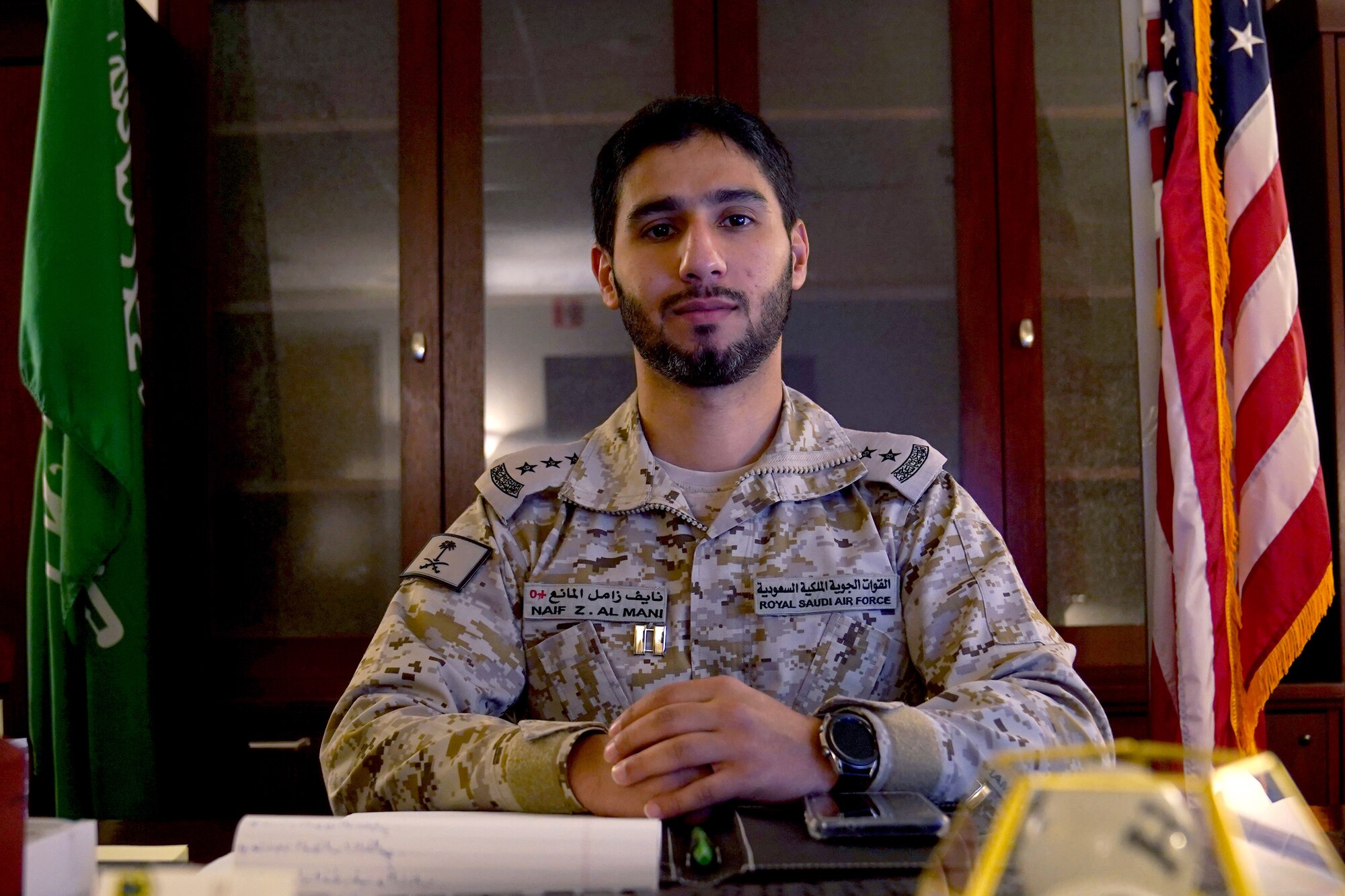 Royal Saudi air force Capt. Naif Almani, Keesler Saudi country liaison officer, poses for a photo at his desk inside the Volser Academic Development Center at Keesler Air Force Base, Mississippi, July 28, 2021. Almani provided his support for the local community by translating exams for a student in the Harrison County School District. (U.S. Air Force photo by Senior Airman Seth Haddix)