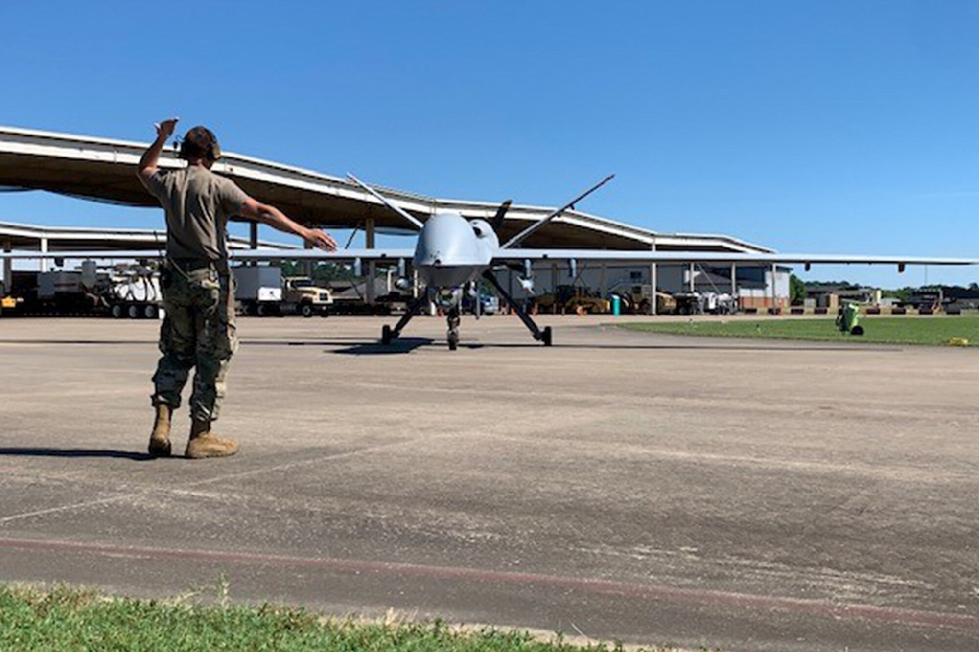 A member of the 147th Attack Wing Aircraft Maintenance Squadron marshals out a MQ-9 Reaper at Ebbing Air National Guard Base, Ark. during joint exercise Establish Fury. The exercise demonstrates the Wing's Immediate Reaction Force feasibility using the Agile Combat Employment concept. (Courtesy Photo)