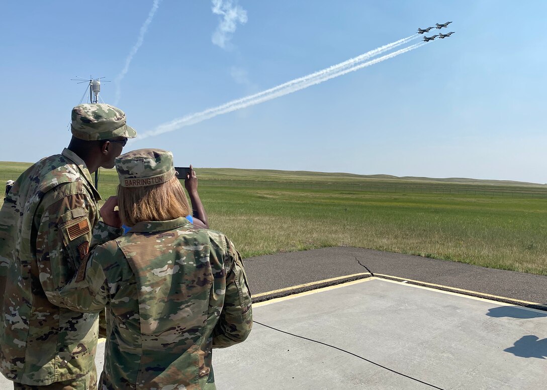 90th Missile Wing Command Chief Nicholas Taylor and 90th Missile Wing Commander Catherine Barrington watch the U.S. Air Force Thunderbirds perform a diamond formation at the Wings over Warren air show July 28, 2021 on F.E. Warren Air Force Base, Wyoming.  Wings over Warren is an annual air show scheduled in conjuction with Cheyenne Frontier Days. (U. S. Air Force photo by Glenn S. Robertson)