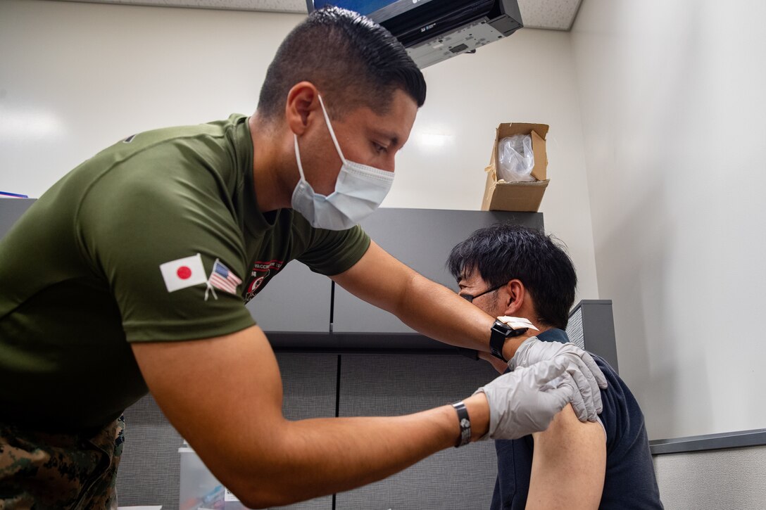 U.S. Navy Petty Officer 1st Class Javier Flores, a hospital corpsman with 3rd Medical Battalion, 3rd Marine Logistics Group, vaccinates a Master Labor Contractor aboard Marine Corps Installations Pacific, at the U.S. Naval Hospital Okinawa on Camp Foster, Okinawa, Japan, July 26, 2021. Vaccinating host-nation employees and military personnel will contribute to the prevention of further spread of COVID-19 in Japan and will protect the resilience of the alliance. (U.S. Marine Corps photo by Lance Cpl. Isaac W. Munce)