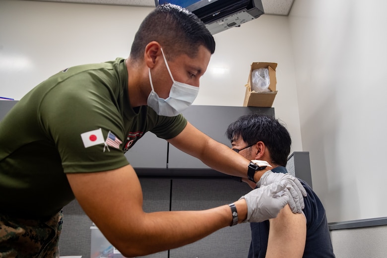 U.S. Navy Petty Officer 1st Class Javier Flores, a hospital corpsman with 3rd Medical Battalion, 3rd Marine Logistics Group, vaccinates a Master Labor Contractor aboard Marine Corps Installations Pacific, at the U.S. Naval Hospital Okinawa on Camp Foster, Okinawa, Japan, July 26, 2021. Vaccinating host-nation employees and military personnel will contribute to the prevention of further spread of COVID-19 in Japan and will protect the resilience of the alliance. (U.S. Marine Corps photo by Lance Cpl. Isaac W. Munce)