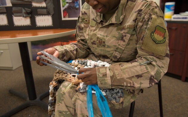 Tech. Sgt. crochets a plastic mat.