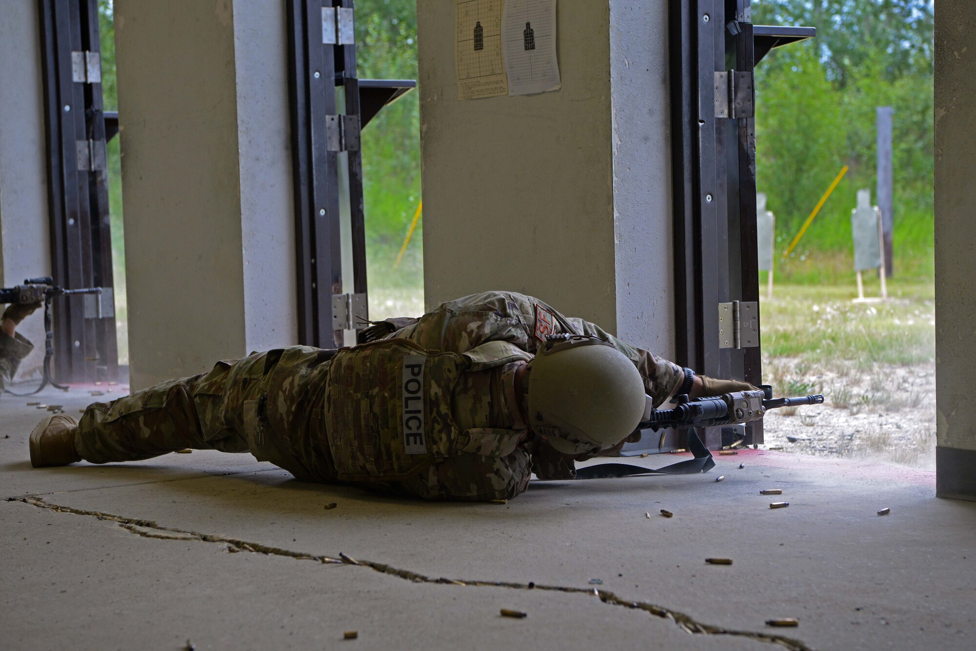 An Airman assigned to the 354th Security Forces Squadron fires an M4 carbine in a new firing position during a new Security Forces Qualification Course on Eielson Air Force Base, Alaska, July 14, 2021. In this proposed course, Defenders will fire from many different positions to simulate firing during an active shooter situation. (U.S. Air Force photo by Senior Airman Beaux Hebert)