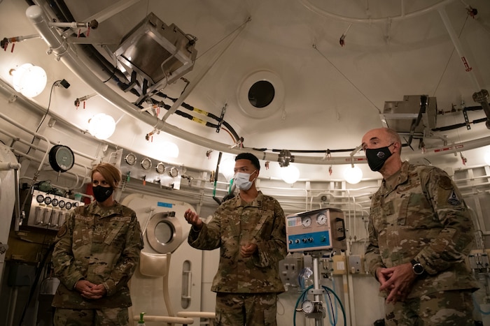 Senior Airman Caleb Harlon, 60th Operational Medical Readiness Squadron licensed vocational nurse technician, center, briefs U.S. Air Force Lt. Gen. Robert Miller, Air Force and Space Force Surgeon General, right, and Chief Master Sgt. Dawn Kolczynski, medical enlisted force and enlisted corps chief, inside a hyperbaric chamber at Travis Air Force Base, California, July 27, 2021.