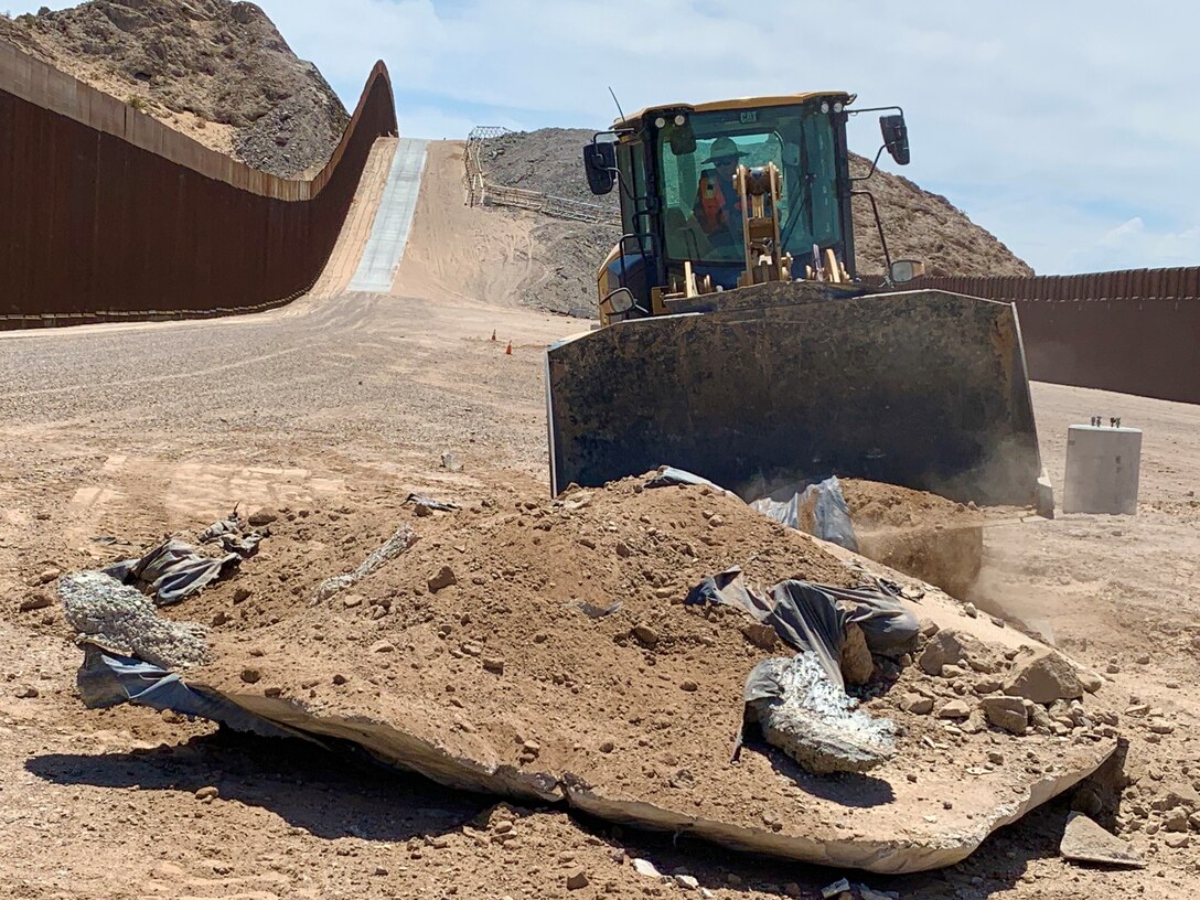 A U.S. Army Corps of Engineers South Pacific Border District contractor removes construction debris at the Yuma 10/27 former wall construction site near Yuma, Arizona, July 19. The District began safety work on July 15 at the Yuma 2 and Yuma 10/27 former wall construction sites in the U.S. Border Patrol’s Yuma sector. This work will not involve expanding the border barrier and specific activities will include filling open trenches, cutting and capping conduit, making gate foundations safe, making maintenance roads safe, and grading around handholds and manholes.