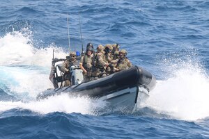 210721-N-N0146-1002 ARABIAN GULF (July 21, 2021) – Royal Navy Sailors and U.S. Navy Sailors operate a rigid hull inflatable boat during a multilateral air operations in support of maritime surface warfare (AOMSW) exercise in the Arabian Gulf, July 21. (U.S. Coast Guard photo by Petty Officer 2nd Class Joseph Perrone)