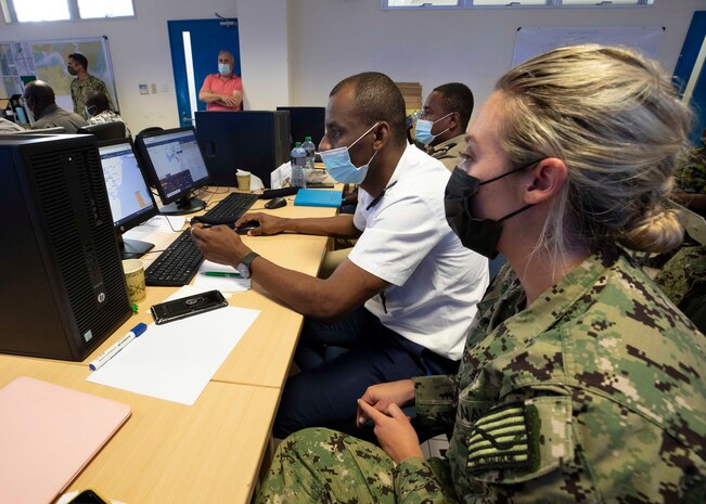 (July 27, 2021)  Yeoman 1st Class Marley Schafer, assigned to U.S. Naval Forces Africa East Detachment 118, Denver, Colo., provides translation support for a Comoros Coast Guard officer in the joint operations center during exercise Cutlass Express 2021, in Mombasa, Kenya, July 27, 2021. Cutlass Express is designed to improve regional cooperation, maritime domain awareness and information sharing practices to increase capabilities between the U.S., East African and Western Indian Ocean nations to counter illicit maritime activity.
