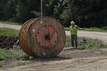 Airmen from five different Engineering Installation Squadrons, including the 205th EIS from Oklahoma, 272nd EIS from Houston, 130th from Utah, and the 223rd EIS from New York, work together to install fiber optics cables across Minnesota's Camp Ripley Training Center's training areas on July 15, 2021.