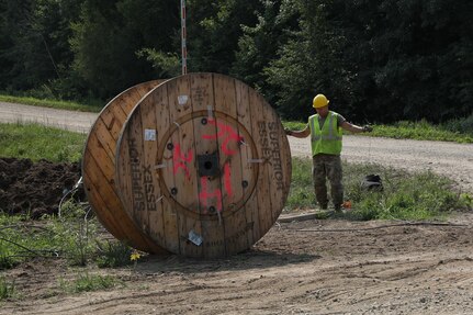 Airmen from five different Engineering Installation Squadrons, including the 205th EIS from Oklahoma, 272nd EIS from Houston, 130th from Utah, and the 223rd EIS from New York, work together to install fiber optics cables across Minnesota's Camp Ripley Training Center's training areas on July 15, 2021.