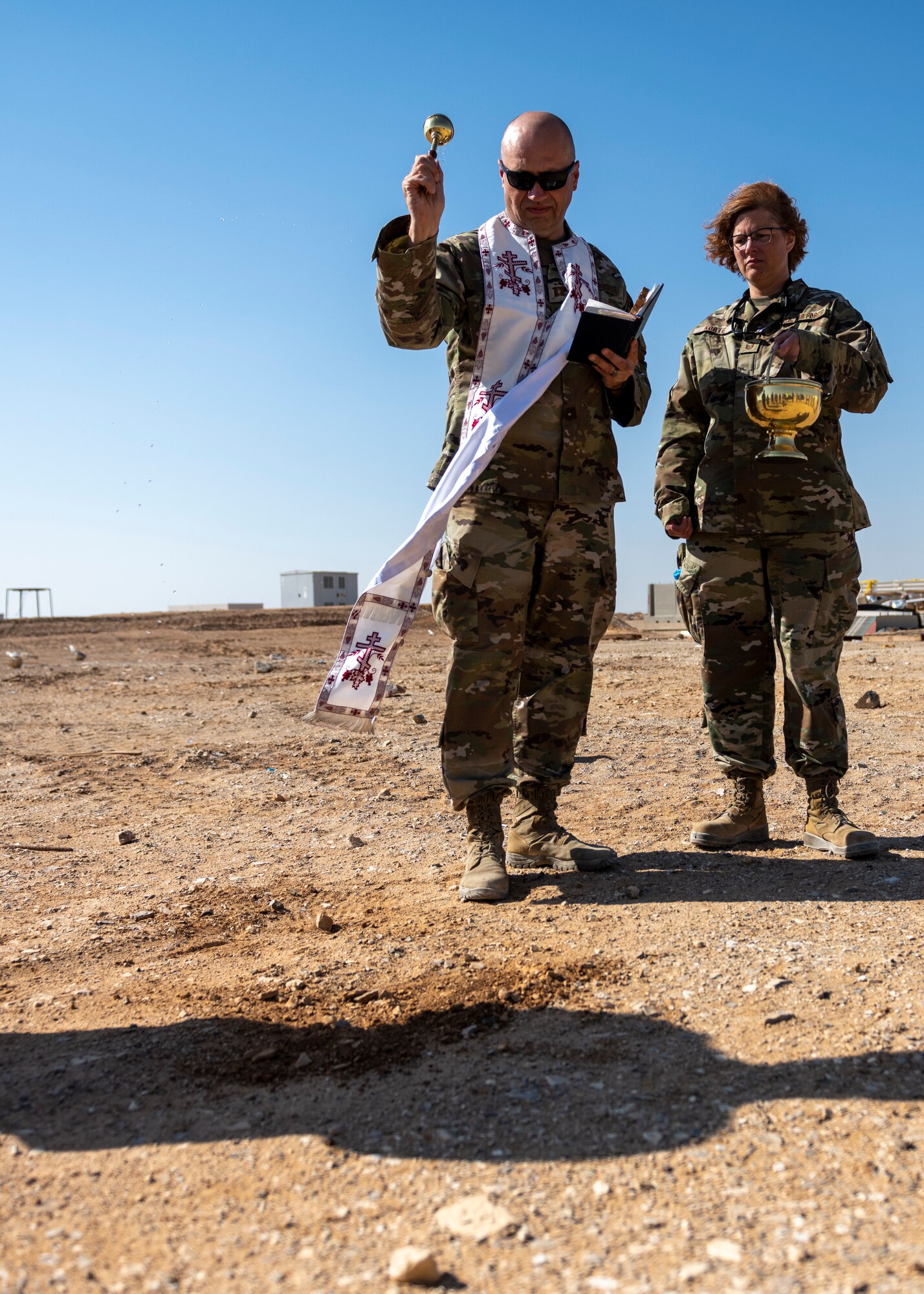 U.S. Air Force chaplain sprinkles holy water on ground