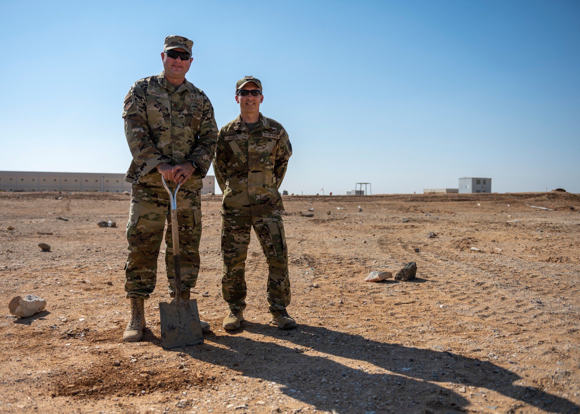Two U.S. Airmen stand at ground breaking site