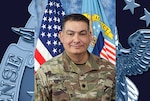 Man in military uniform with 2 flags behind him