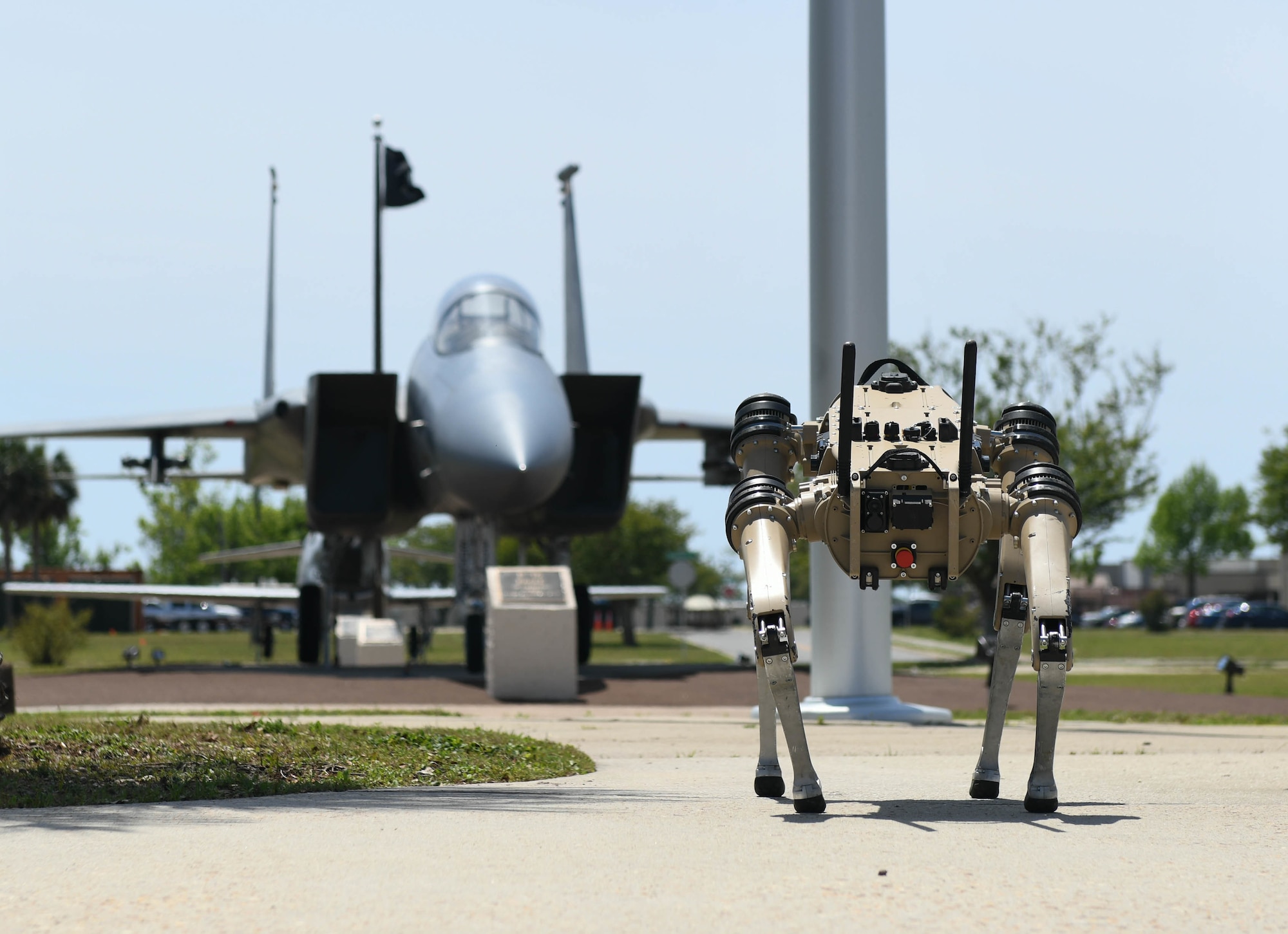 An Unmanned Quad-legged Ground Vehicle stands in front of a jet