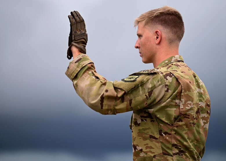 An Airman assigned to the 41st Airlift Squadron directs the driver of a High Mobility Multipurpose Wheeled Vehicle into a C-130J Super Hercules