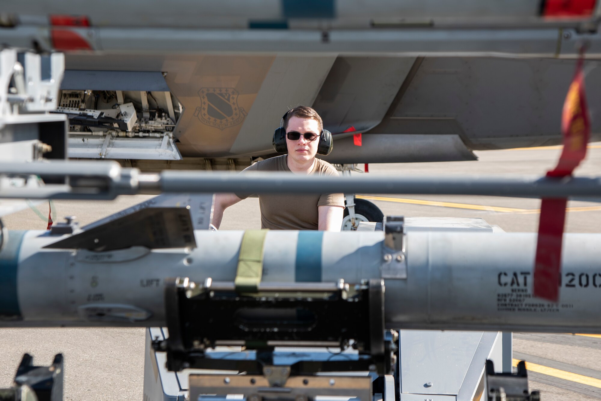 U.S. Air Force Airman 1st Class Seth McClain, a 90th Aircraft Maintenance Unit weapons load crew member, lifts an AIM-120 missile with an MJ-1 bomb lift during a Weapons Load Crew of the Quarter competition at Joint Base Elmendorf-Richardson, Alaska, July 1, 2021. Airmen from the 525th and 90th Aircraft Maintenance Units competed for the title of the 3rd Maintenance Group Load Crew of the Quarter.