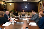 Group of DLA employees sit at conference table.