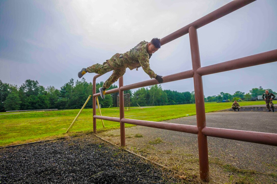 A soldiers maneuvers over an obstacle.