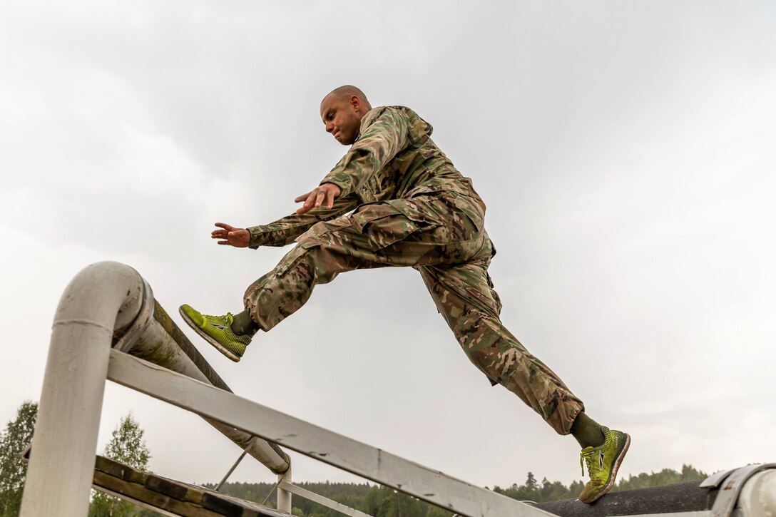 A soldier jumps over an obstacle.