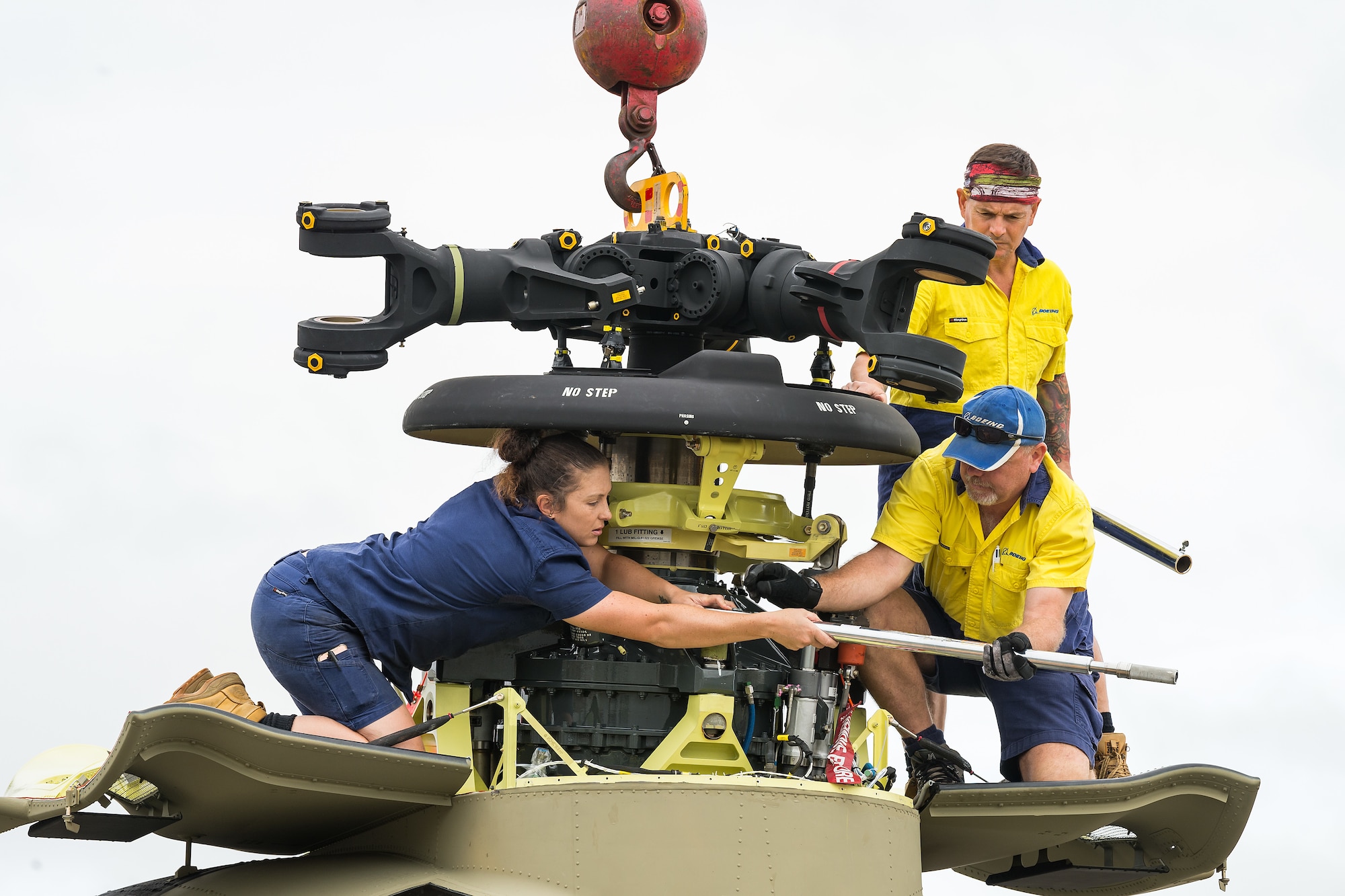 Boeing Defence Australia maintenance team members remove a bolt from the forward transmission on a CH-47F Chinook helicopter  at Dover Air Force Base, Delaware, June 12, 2021. BDA maintenance personnel readied two Chinooks for shipment aboard a C-5M Super Galaxy as part of the U.S. government’s foreign military sales program. The U.S.-Australia alliance is an anchor for peace and stability in the Indo-Pacific region and around the world. (U.S. Air Force photo by Roland Balik)