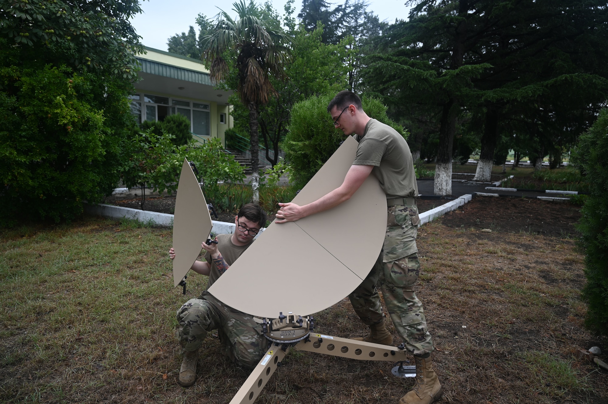 U.S. Air Force Staff Sgt, Brenden Lowe, 1st Combat Communications Squadron radio frequency transmission systems supervisor, left, and Airman First Class Isaac Peebles, 1st CBCS radio frequency transmission systems, build a tactical satellite during exercise Agile Spirit 21