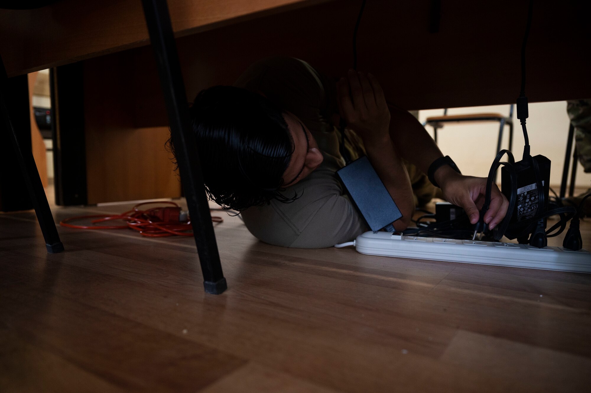 U.S. Air Force Staff Sgt. Jacob Morin, 1st Combat Communications Squadron client systems technician, connects power cords into a power strip during exercise Agile Spirit 21