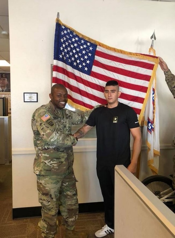 man standing with a younger man in front of flags.