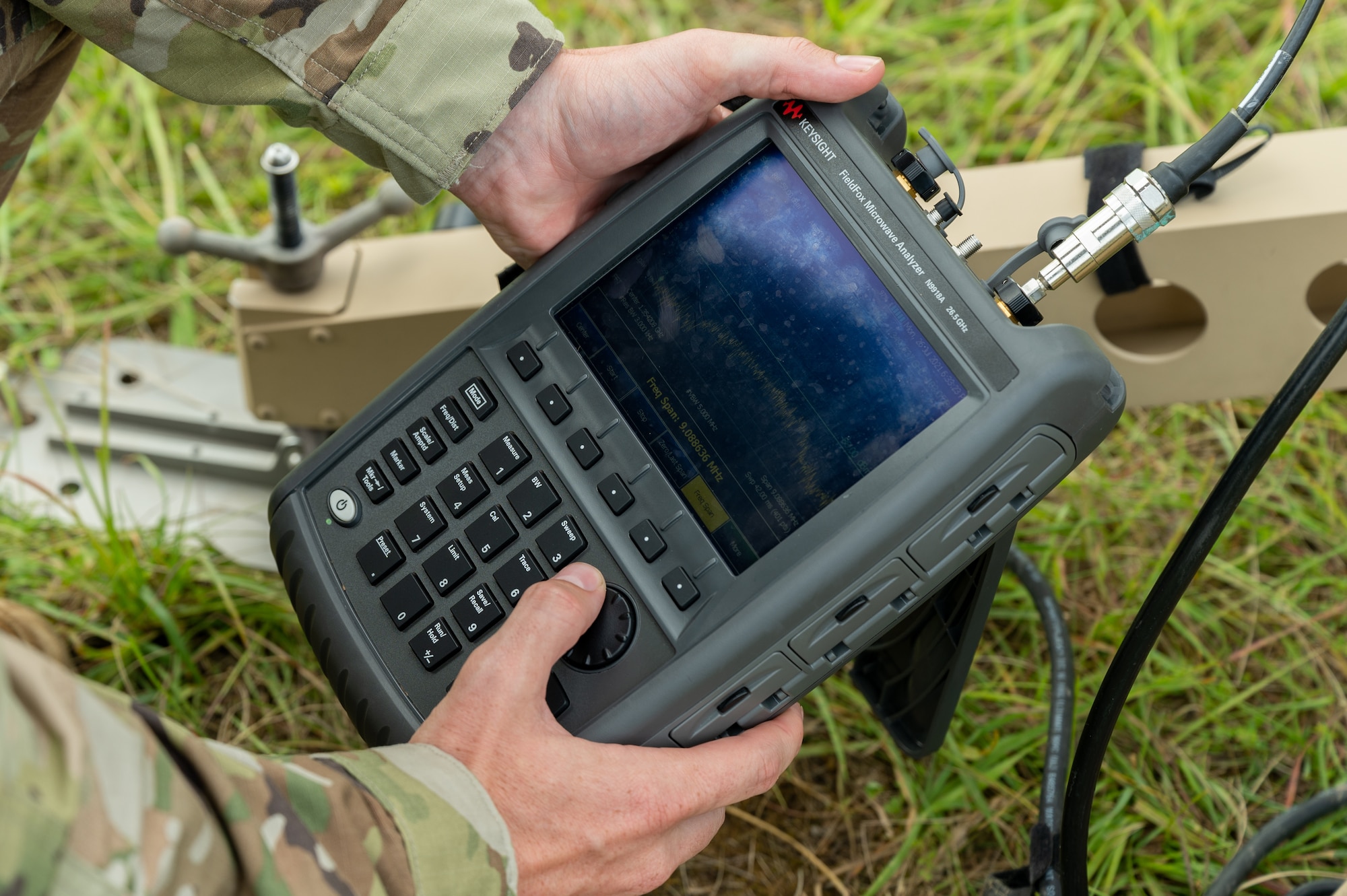 Close-up of hands holding a frequency measuring device.